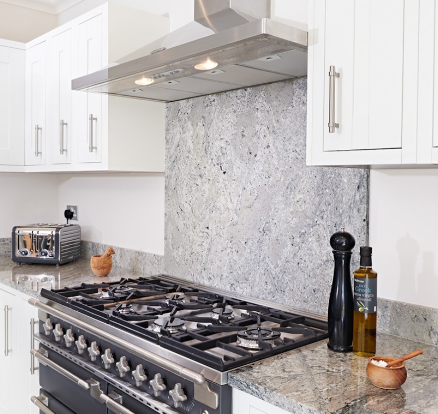 Modern kitchen featuring a grey granite splashback installed behind cooker.