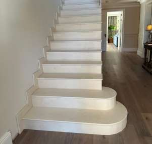 Striking staircase fully clad in limestone with matching stone treads and risers.