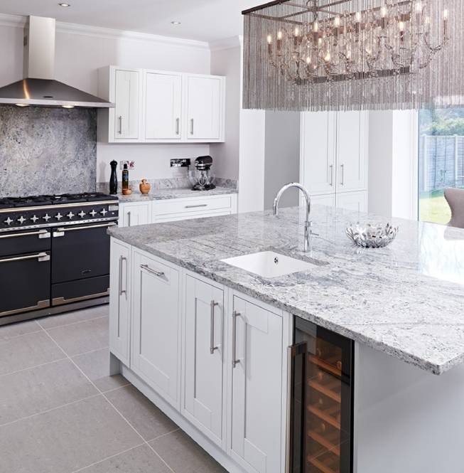 Large modern kitchen with grey granite worktops featuring a large island with matching granite upstands and splashback